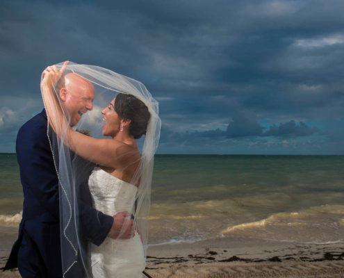 bride and groom have fun on beach after wedding.