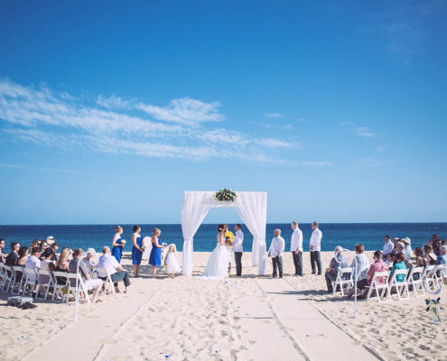 wedding ceremony on beach with guests and ocean in background in Cabo, Mexico