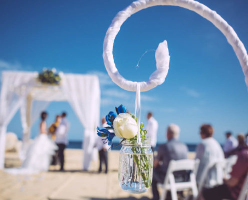 beach wedding details with couple in distance