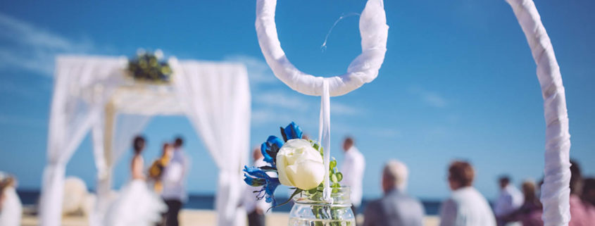beach wedding details with couple in distance