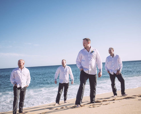 Groom and his party stand on beach