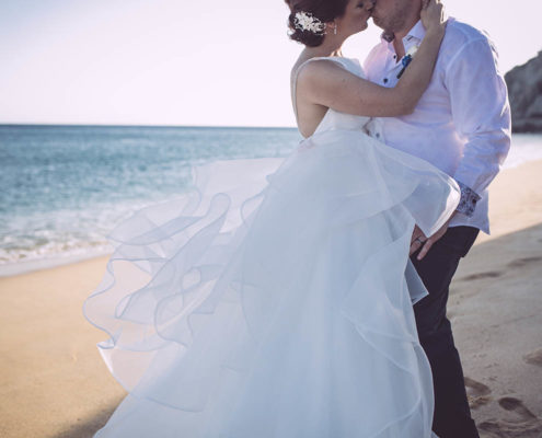 bride and groom kiss on the beach