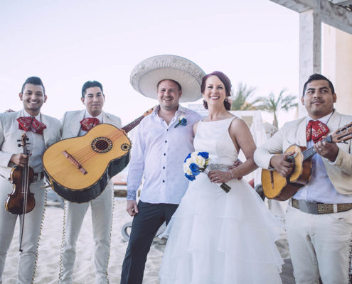 bride and groom smile with Mexican musicians in background