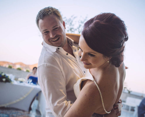 groom smiles while dipping bride during dance at wedding