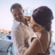 groom smiles while dipping bride during dance at wedding