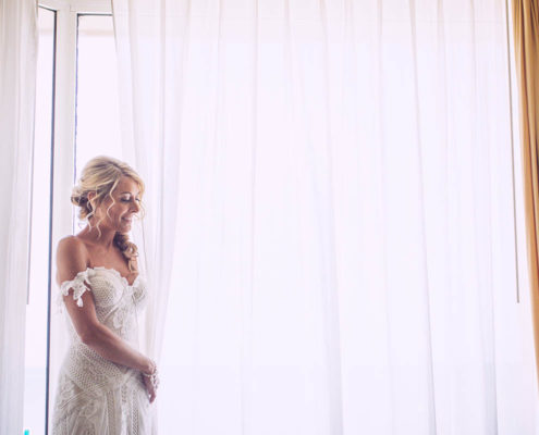 bride waiting by window before ceremony