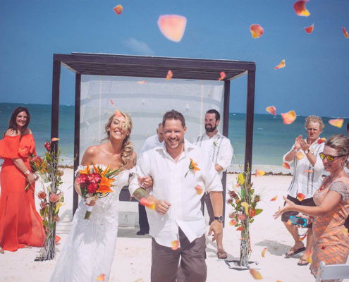 newly wed couple walking away from altar at beach wedding