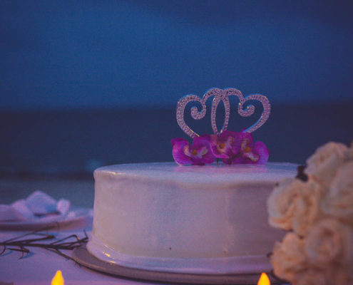 wedding cake at destination wedding in Mexico with beach in background