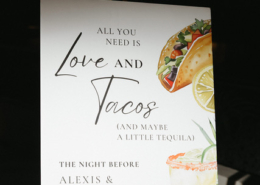 Personalized wedding welcome party sign reading "All You Need Is Love and Tacos," featuring colorful taco and cocktail illustrations for Alexis and Catalina's Mexico destination wedding.